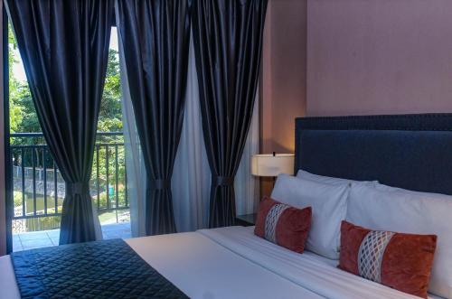 a bedroom with a bed and a large window at Noble Cebu Hotel in Cebu City