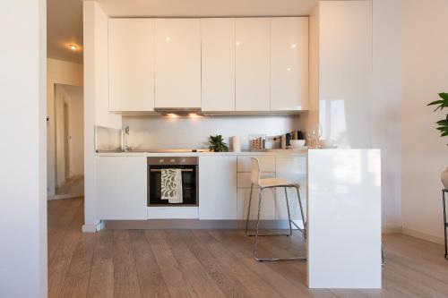 a kitchen with white cabinets and a stove top oven at Premium Studio Apartment in Herastrau with City View in Herăstrău