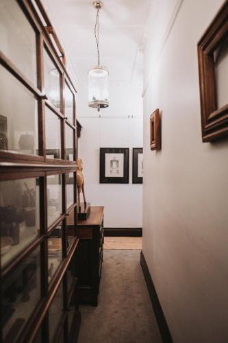 a hallway with a room with paintings on the wall at Lindsay House Guest House in Armidale