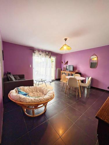 un salon avec des murs violets, un canapé et une table dans l'établissement Beauregard, à La Rochelle