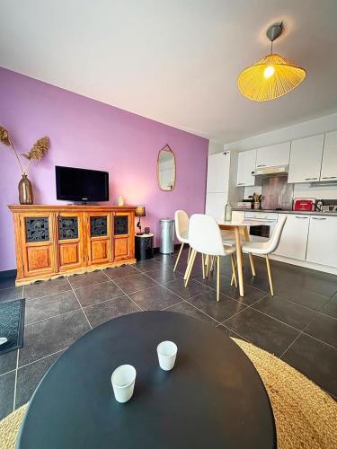 un salon avec une table et une cuisine dans l'établissement Beauregard, à La Rochelle