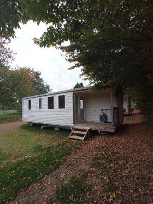 a small white trailer parked in a field at Camping Le vélodrome in Albert