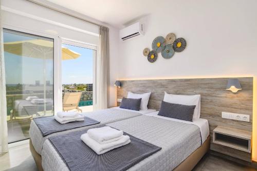 une chambre avec un grand lit avec des serviettes dessus dans l'établissement Villa Amethyst Gem by Villa Plus, à Gennadi