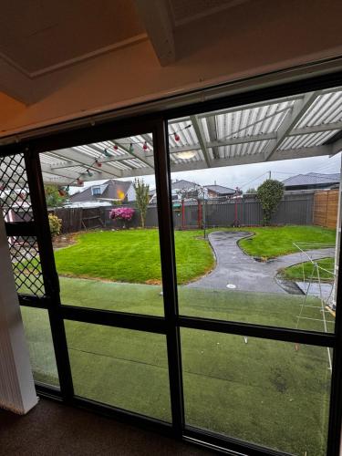 a view through a window of a yard at Relax In Mosgiel in Mosgiel