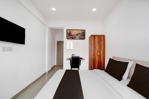 a hotel room with a bed and a desk at Collection O Laxmi Chowk Hinjewadi in Hinjewadi