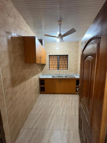 a kitchen with a sink and a ceiling fan at Kasoa Stay in Kasoa