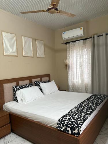 a bedroom with a bed and a ceiling fan at Kasoa Stay in Kasoa