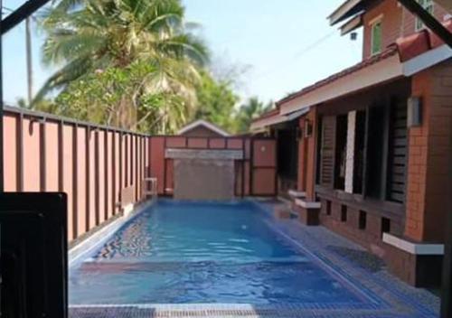 a large swimming pool in front of a building at Villa Ilham in Langkawi Intl