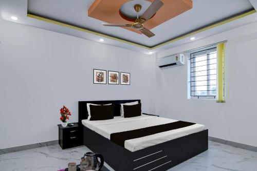 a bedroom with a bed and a ceiling fan at Super Collection O Mourigram Near Andul Road in Sānkrāil