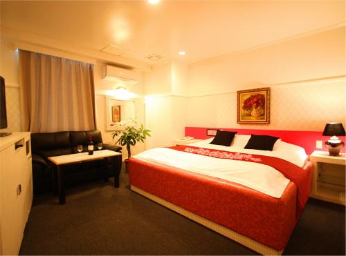 a hotel room with a large bed and a chair at ホテル 白雪姫 -水島インターチェンジ隣- in Kurashiki