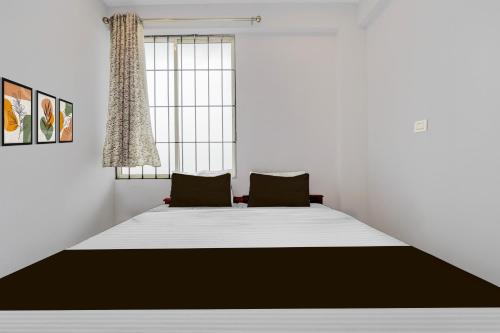 een slaapkamer met een groot bed en 2 stoelen bij Super Hotel O Pukkattupady Aluva East in Cochin