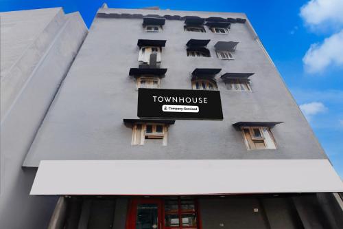 a tall building with a sign on the side of it at Townhouse Nagpur Junction Formerly Hotel Woodland in Nagpur
