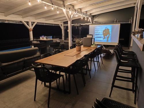 ein Konferenzraum mit Tisch und Stühlen und einer Leinwand in der Unterkunft Family House Roza in Gračec