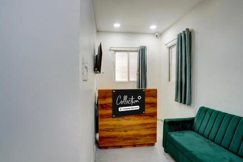 a living room with a green couch and a sign at Collection O Nashik Central Railway Junction Formerly Dream Heritage Inn in Nashik