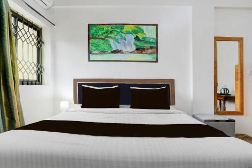 a bedroom with a bed and a painting on the wall at Collection O Candolim Beach Formerly Poornima Place in Candolim