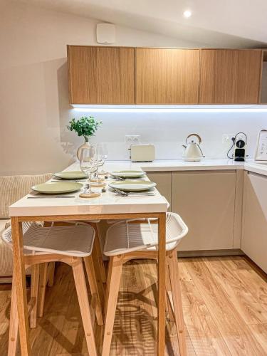 cocina con mesa de madera con sillas y barra en La Cahute Rochelaise - Cosy dans le centre-ville à 5 min du port, en La Rochelle