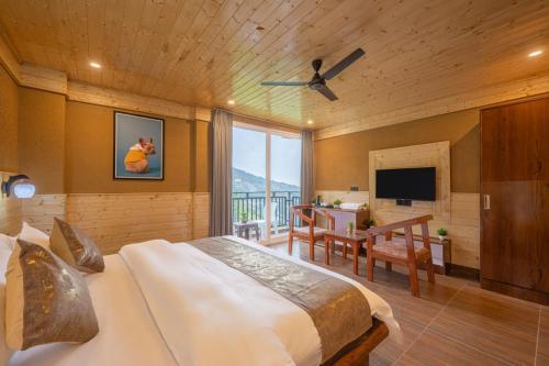 a bedroom with a bed and a desk and a television at The Charvi Retreat by Exotic Stays in Shimla