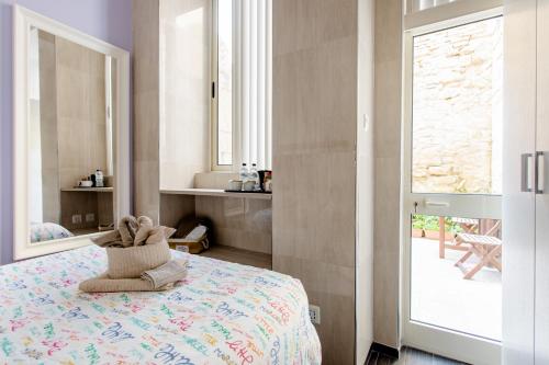 a bedroom with a bed with a teddy bear on it at Nemy Sliema Guesthouse in Sliema