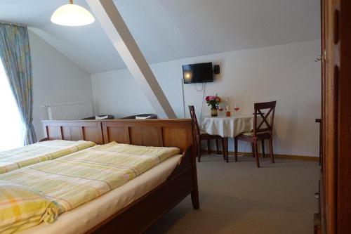a bedroom with a bed and a table with a dining room at Weingut Pension Heinz Dostert in Nittel