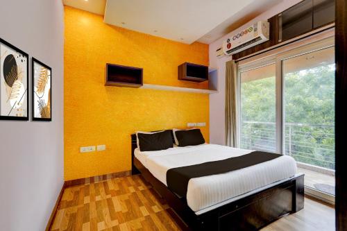 a bedroom with a bed and a yellow wall at Hotel O Ashok Nagar Metro Station Chennai Formerly G Cloud in Chennai