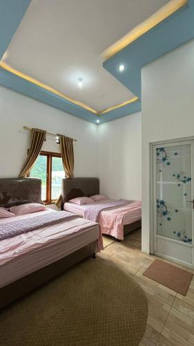 a room with two beds and a window in it at Rahayu Cabin Villa in Dieng