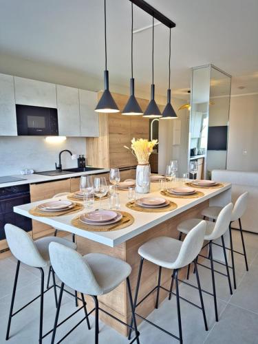 a kitchen with a large table with chairs and glasses at Escapade Rochelaise in La Rochelle
