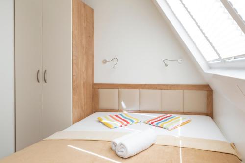 a small bed in a room with a skylight at Floating House Marina in Portorož