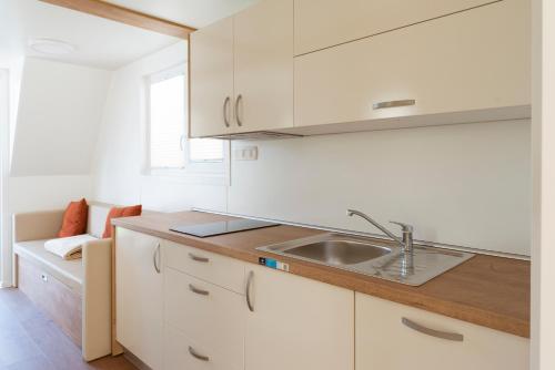 a kitchen with white cabinets and a sink at Floating House Marina in Portorož