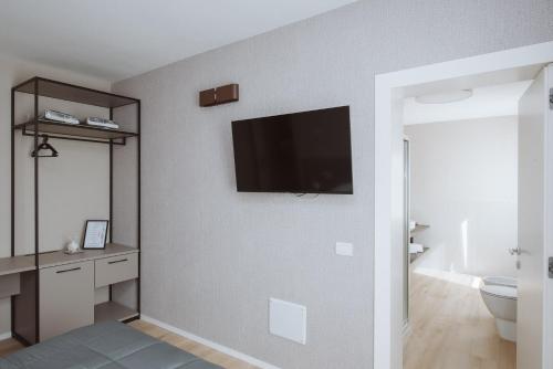 une salle de bain avec une télévision à écran plat sur un mur dans l'établissement Locanda Madonna di sotto, à Sassuolo