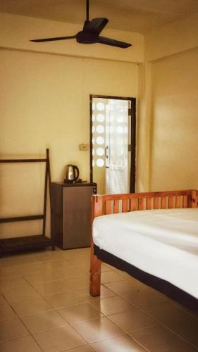 a bedroom with a bed and a ceiling fan at Boutique House Nipha in Chiang Mai