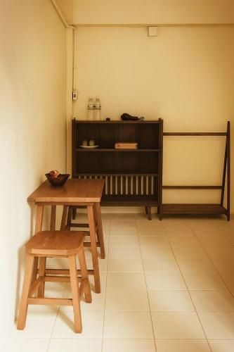 a room with a table and two chairs and a shelf at Boutique House Nipha in Chiang Mai