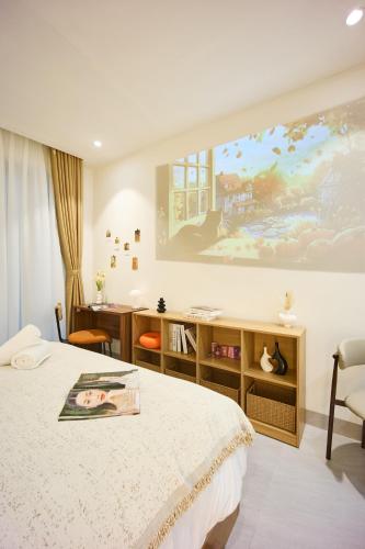 a bedroom with a bed and a painting on the wall at take me 3seasons - hidden boutique home right at Han Market in Danang