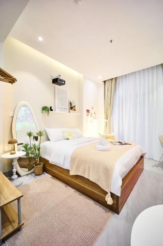 a bedroom with a large bed and a large window at take me 3seasons - hidden boutique home right at Han Market in Danang