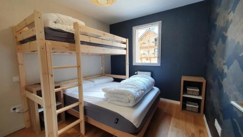 a bedroom with two bunk beds and a window at Beau logement 5 pers, proche de toutes commodités in Loudenvielle
