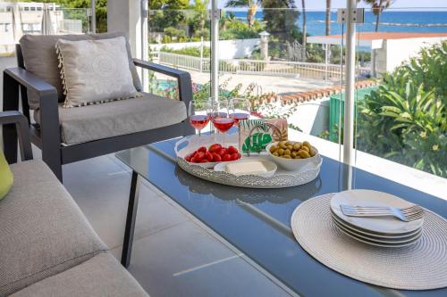 a table with a plate of food and glasses of wine at Berengaria Court - Sea Views 2bdr Apartment in Limassol