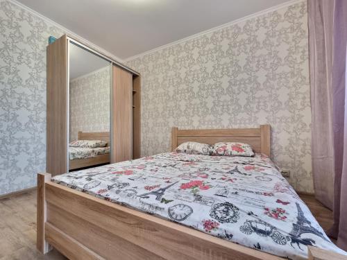 a bedroom with a bed and a mirror at Your Flat Lebedinny in Kyiv