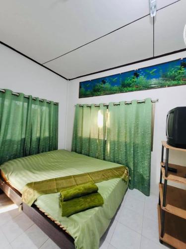 a bedroom with a green bed with green curtains at Pineapple Resort Sam roi yot in Sathani Sam Roi Yot