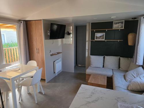 a living room with a couch and a table at amorosa mobil home in Canet-en-Roussillon