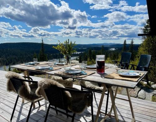 una mesa de madera con sillas en una terraza con vistas en Ål Cabin With Panoramic Views, en Favang