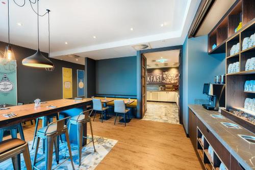 un restaurante con paredes azules y un bar con taburetes en Premier Inn Dresden City Prager Straße, en Dresden