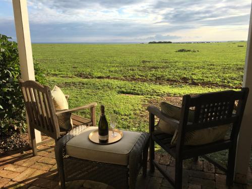 a patio with two chairs and a table with a bottle of wine at Cable Station Accommodation in Stanley
