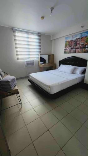 a bedroom with a large bed and a window at Comfy Condo Mactan Cebu in Sampong