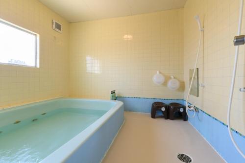 une salle de bain avec une baignoire bleue et une douche dans l'établissement OYO Ryokan Hamanako no Yado Kosai - Vacation STAY 38823v, à Kosai