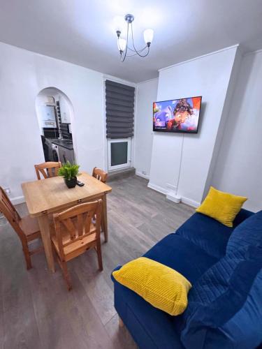 a living room with a blue couch and a table at House for 8 in Gillingham close to train station with free parking in Gillingham
