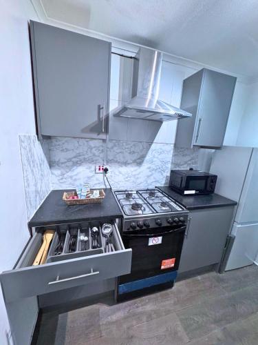 a kitchen with a stove and a counter top at House for 8 in Gillingham close to train station with free parking in Gillingham