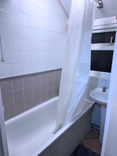 a bathroom with a bath tub and a sink at House for 8 in Gillingham close to train station in Gillingham