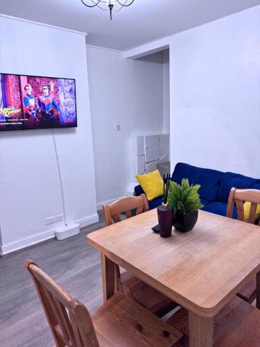 a living room with a wooden table and a couch at House for 8 in Gillingham close to train station with free parking in Gillingham