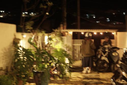 a man standing next to a motor scooter at night at Brownie Home Dalat in Da Lat