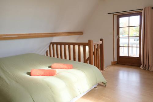 a bedroom with a bed with two pillows on it at La Sellerie et Le Relais des Hortensias in Graincourt