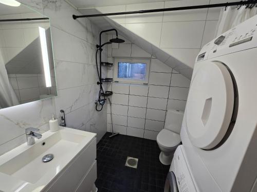 a white bathroom with a sink and a toilet at Grete's House in Eurajoki